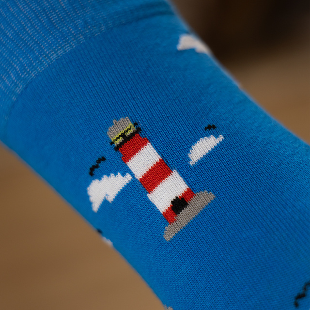 Colorful mismatched SOXO GOOD STUFF socks lighthouse