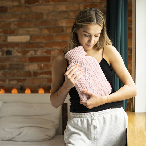 SOXO pink hot water bottle warmer in a sweater